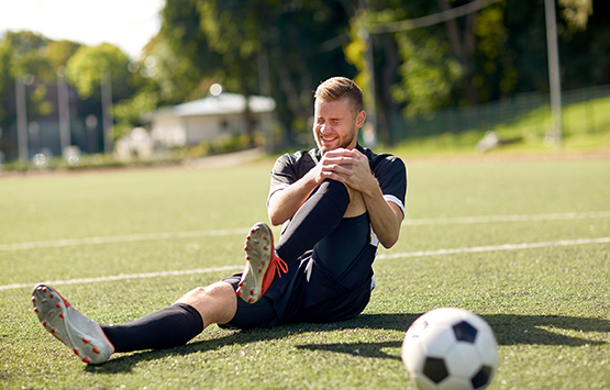 Male soccer player in pain with knee injury