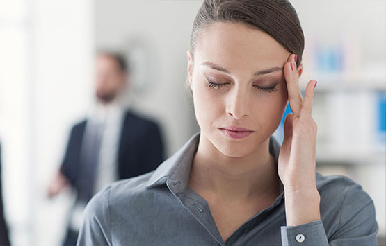 Woman holding her head with extreme migraine