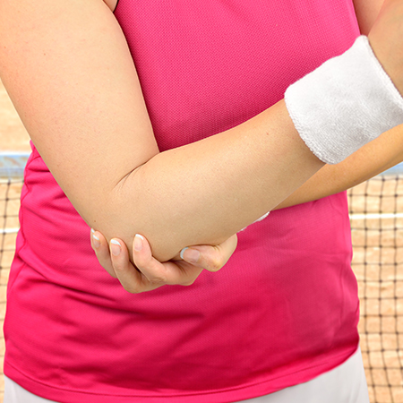 Woman suffering with tennis elbow in need of chiropractic care in Livermore
